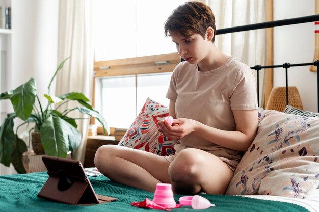 Mujer sosteniendo tiro completo de copa menstrual