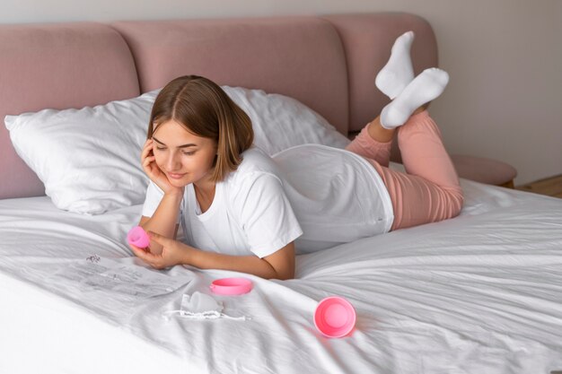 Mujer sosteniendo tiro completo de copa menstrual