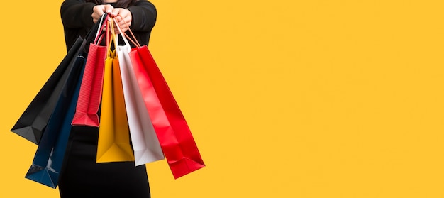 Mujer sosteniendo varias bolsas de compras espacio de copia