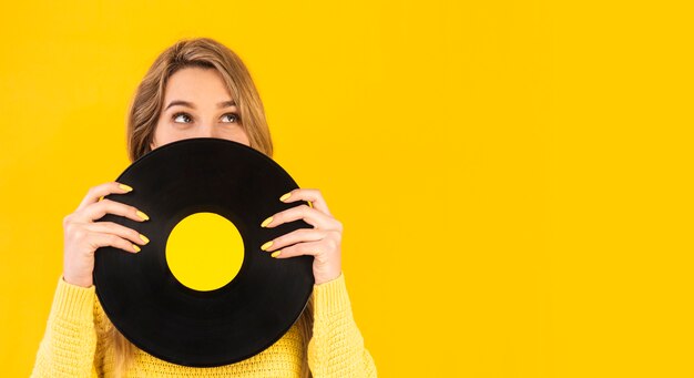 Mujer sosteniendo vinilo con espacio de copia