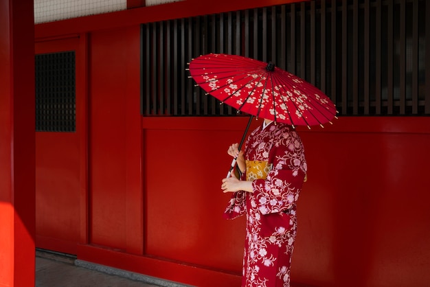 Mujer sosteniendo vista lateral de paraguas wagasa