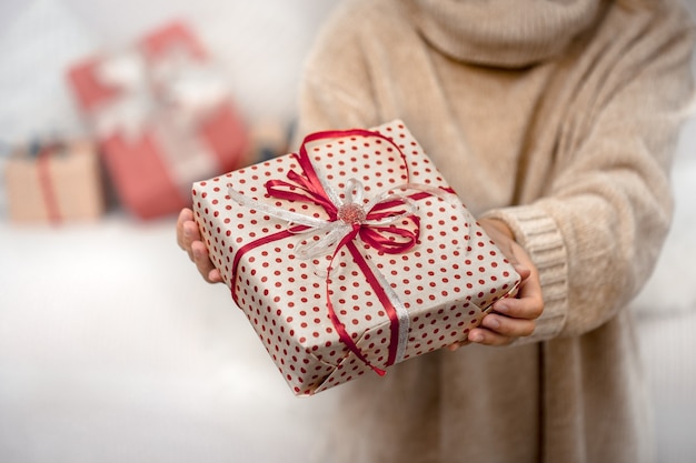 Una mujer sostiene un hermoso regalo de Navidad.