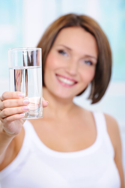 Mujer sostiene un vaso de agua limpia