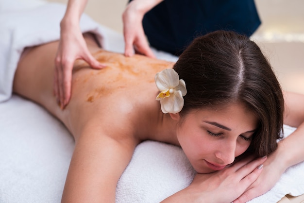 Mujer en el spa disfrutando de un masaje de espalda