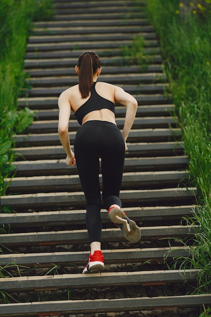 Mujer en un spoerswear negro de pie en una escalera