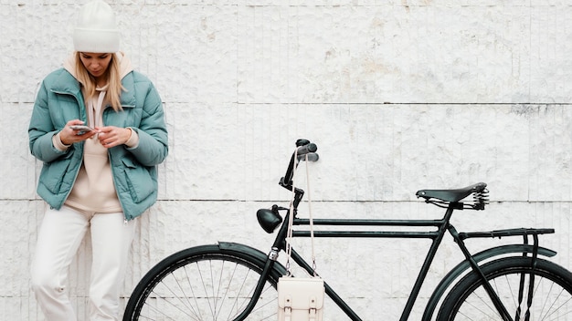 Foto gratuita mujer con su bicicleta tomando un descanso vista frontal