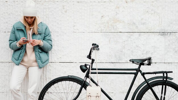 Mujer con su bicicleta tomando un descanso vista frontal