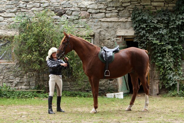 Mujer y su caballo marrón