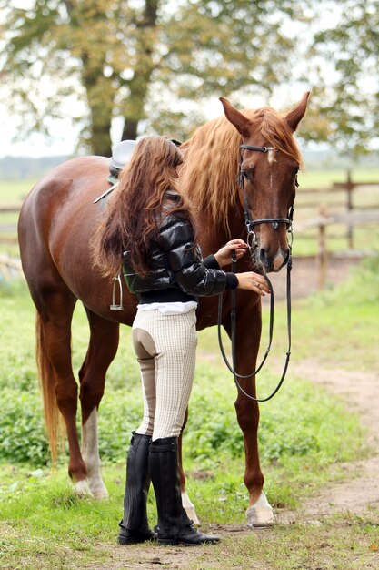 Mujer y su caballo marrón