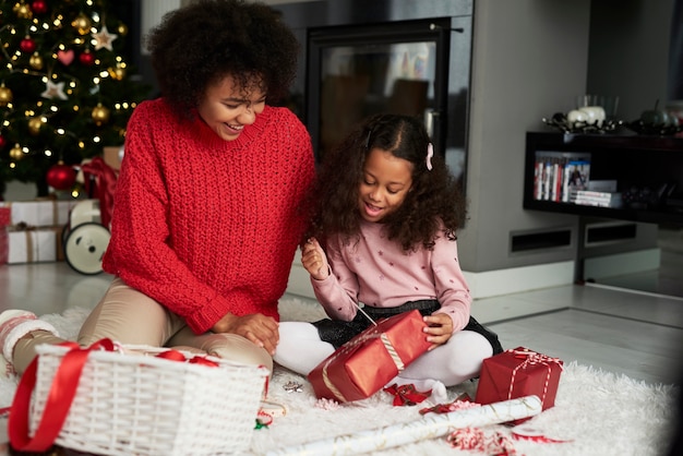 Mujer y su hija envolviendo regalos de Navidad