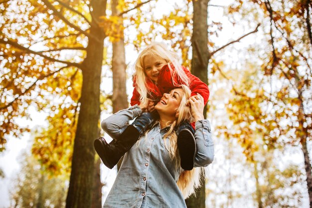 Mujer con su hija pequeña sobre los hombros