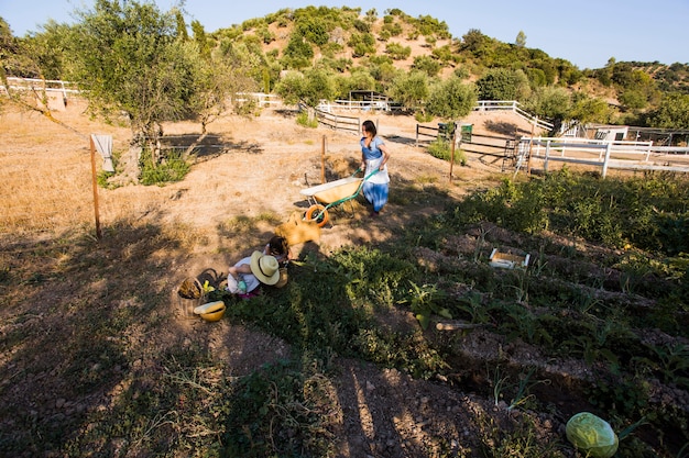 Mujer y su hija trabajando en el campo.