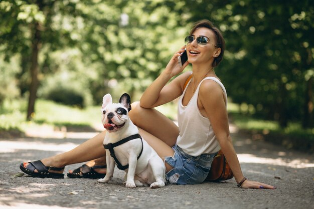 Mujer con su mascota bulldog francés hablando por teléfono