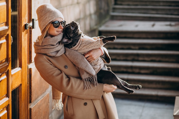 Mujer con su mascota bulldog francés saliendo