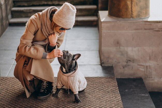 Mujer con su mascota bulldog francés saliendo