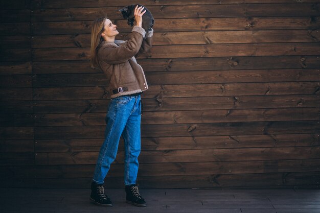 Mujer con su mascota bulldog francés sobre fondo de madera