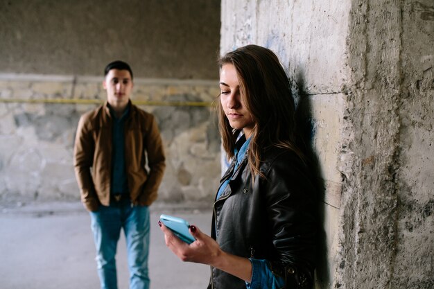 Mujer con su móvil sería y el novio de fondo