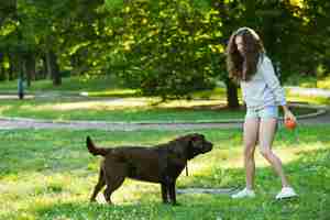 Foto gratuita mujer y su perro jugando en la hierba