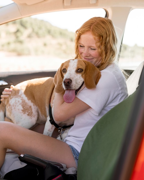 Mujer y su perro sentados en el coche