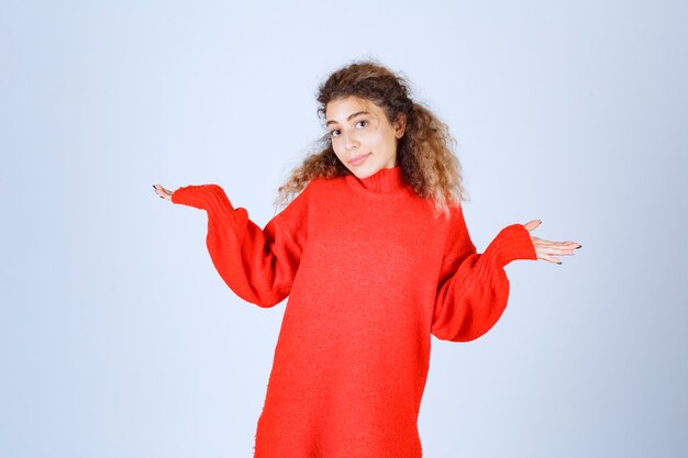 mujer con una sudadera roja apuntando a diferentes lados.