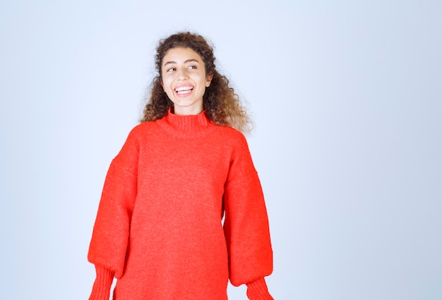 mujer en sudadera roja dando poses neutrales.