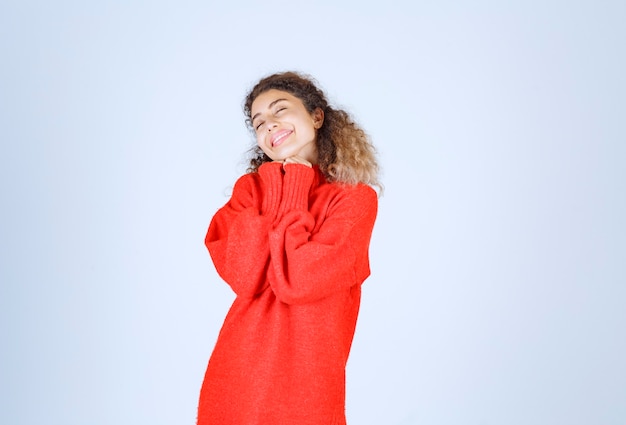 Foto gratuita mujer en sudadera roja dando poses sonrientes y seductoras.