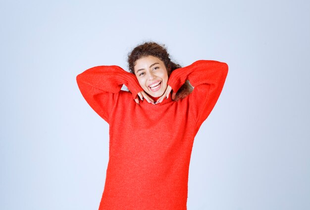 mujer en sudadera roja dando poses sonrientes y seductoras.