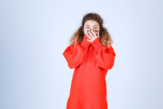 Foto gratuita mujer en sudadera roja parece aterrorizada y asustada.