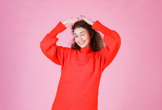 mujer en sudadera roja parece exhausta y con sueño.