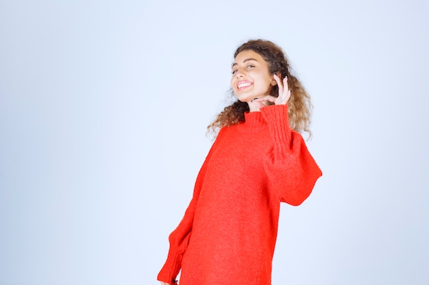 mujer en sudadera roja que muestra el signo de disfrute.