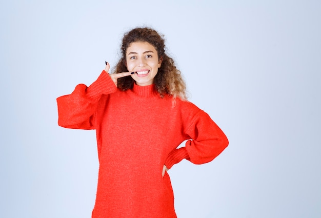 mujer en sudadera roja que significa su sonrisa.