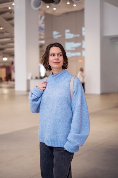 mujer, en, suéter azul, tenencia, bolsa, dentro