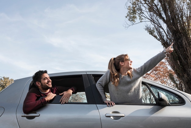 Foto gratuita mujer en suéter colgando de la ventana del coche