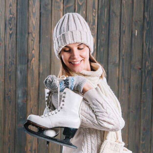 Mujer en suéter con patines detrás de la espalda.