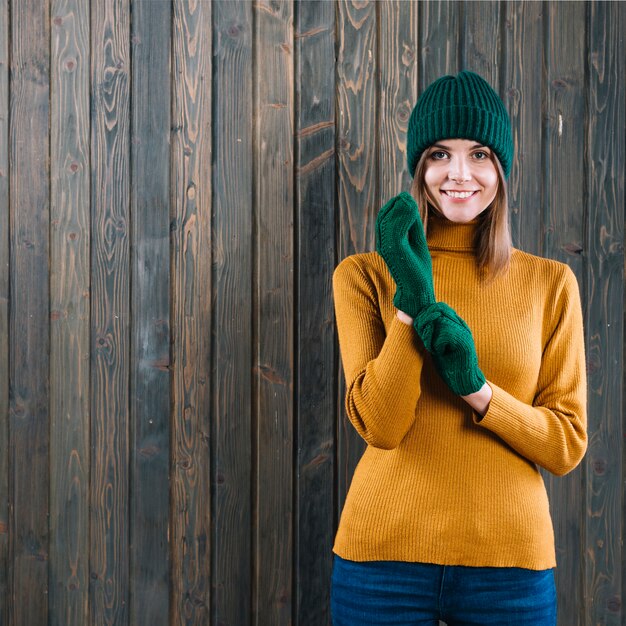 Mujer en suéter poniéndose guantes