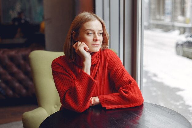 Mujer con un suéter rojo. Señora en un restaurante.