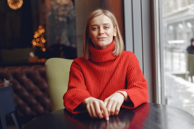 Mujer con un suéter rojo. Señora en un restaurante.