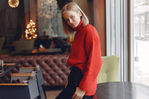 Mujer con un suéter rojo. Señora en un restaurante.