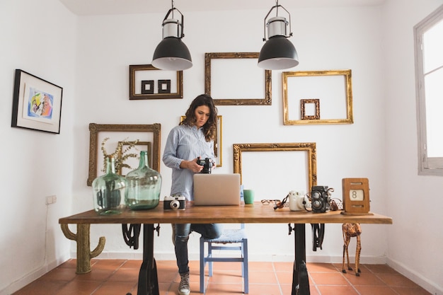 Foto gratuita mujer sujetando una cámara en su lugar de trabajo