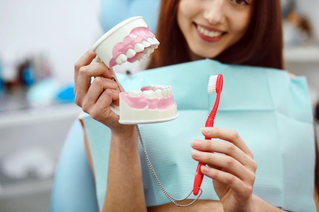 Mujer sujetando un cepillo de dientes y un molde dental