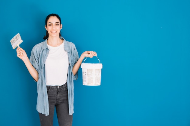 Mujer sujetando pincel y cubo