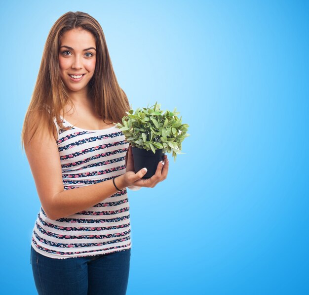 Mujer sujetando una planta con sus manos