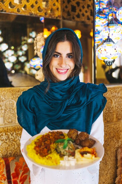 Mujer sujetando plato de comida arabe