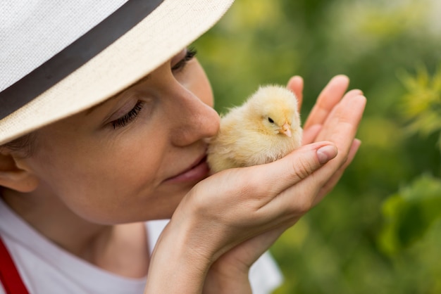 Mujer sujetando un pollo en una granja