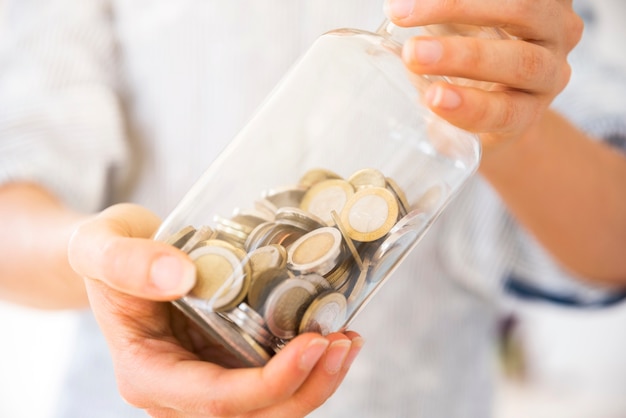 Mujer sujetando un tarro con dinero