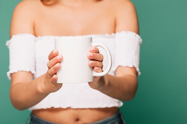 Foto gratuita mujer sujetando una taza con ambas manos