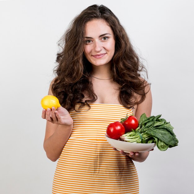 Mujer sujetando verduras y frutas