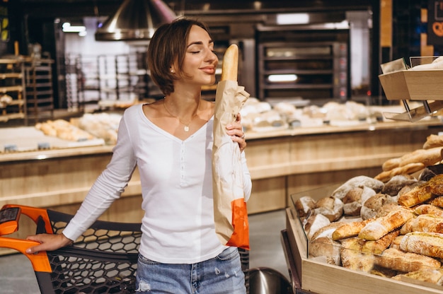 Mujer en el supermercado comprando pan fresco