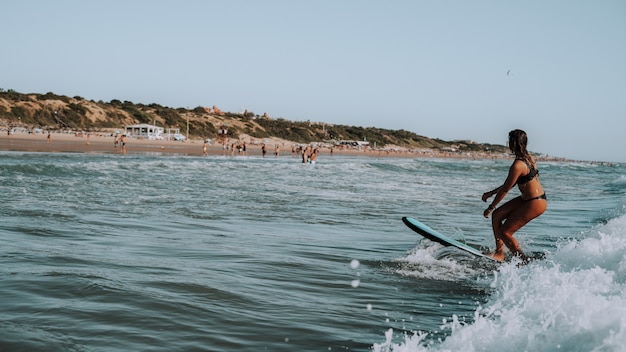 Mujer surfeando en olas pequeñas