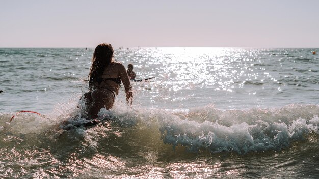 Mujer surfeando en olas pequeñas